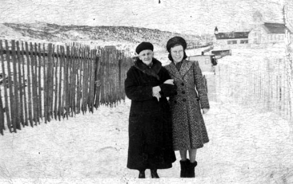 308: Mollie McCarthy and her grandmother Mrs. Stasia Dunphy, with the church and old school in the  background. Leo Whalen's garden fence is on the left; Thomas Rose's house is in the background. (1940)  - Mollie daughter of James McCarthy &amp;amp; Julia Reddy; Mrs. Stasia the wife of Patrick Dunphy &amp;amp; the widow of Thomas McCarthy